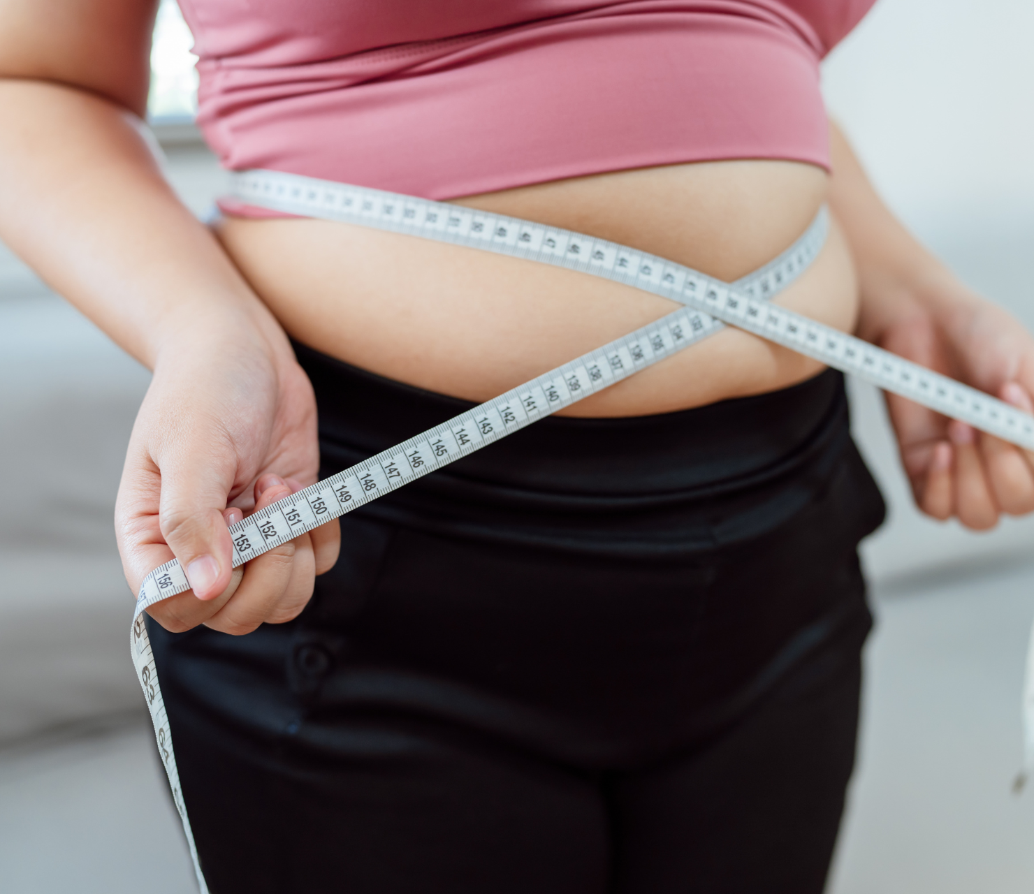 woman measuring waist line for weight loss